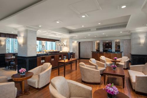 a lobby with chairs and tables and a bar at Crowne Plaza Amman by IHG in Amman