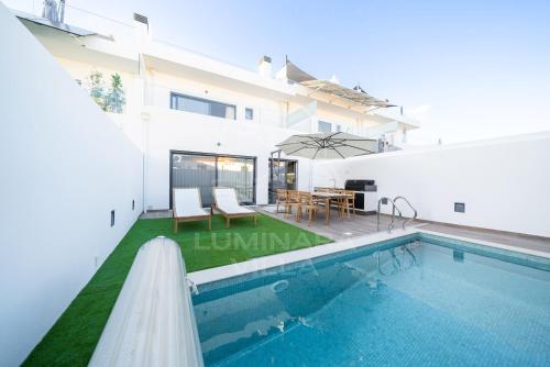 a villa with a swimming pool and a house at Luminara Villa in Santa Luzia
