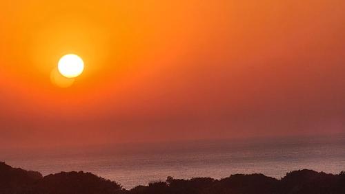 a sunset over the ocean with the sun in the sky at Seaview Villa 25 in Shelly Beach