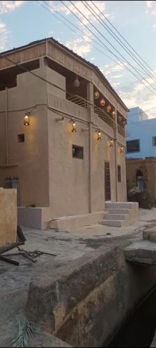 a building with lights on the front of it at Sehma Guest House بيت السحمه للضيافه in Al Ḩamrāʼ