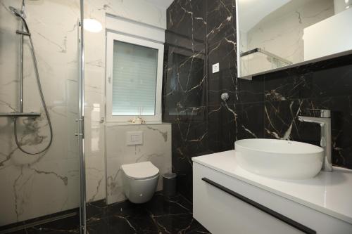 a bathroom with a sink and a toilet and a shower at Sea&Sand Apartment - Modern Sea View near Sandy Beaches in Privlaka