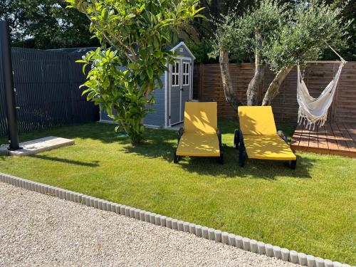 メーズにあるPetite maison individuelle proche plageの庭にある2脚の黄色い椅子とハンモック