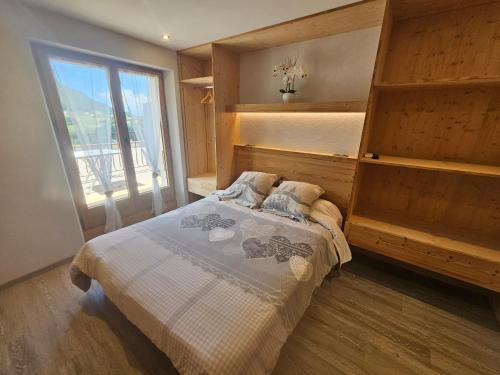 a bedroom with a bed and a large window at Hôtel Plein Soleil in Vacheresse