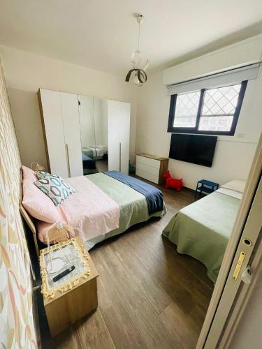 a bedroom with two beds and a window at Casa Politeama Spacious Central Flat by Oplonti Station for Pompeii, Sorrento and Naples in Torre Annunziata