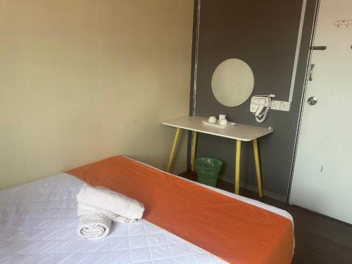 a room with a bed and a table with a mirror at Jenny Homestay in Teluk Intan