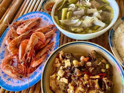 a table with three bowls of food and a bowl of rice at Khu nghỉ dưỡng sinh thái Apsara Sóc Trăng in Ấp Vĩnh Hưng
