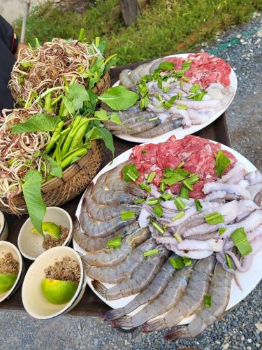 a table with three plates of seafood and vegetables at Khu nghỉ dưỡng sinh thái Apsara Sóc Trăng in Ấp Vĩnh Hưng