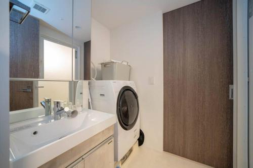 a bathroom with a sink and a washing machine at Journey-Tanukikouji-MD303 in Sapporo