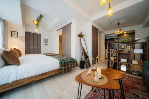a bedroom with a bed and a table and a couch at Journey-Tanukikouji-MD303 in Sapporo