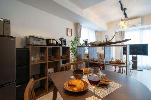 a kitchen with a table with two glasses of wine at Journey-Tanukikouji-MD303 in Sapporo