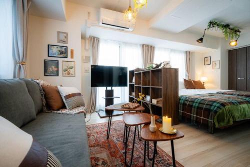 a living room with a bed and a couch at Journey-Tanukikouji-MD303 in Sapporo