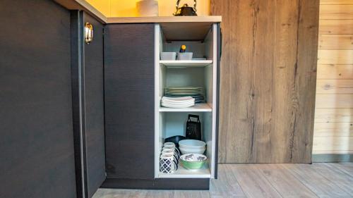 a cupboard with plates and dishes in it at Strazdu Māja in Jūrmala