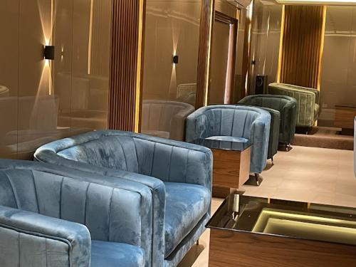 a living room with three blue couches and a table at Phoenix Holidays in Cochin