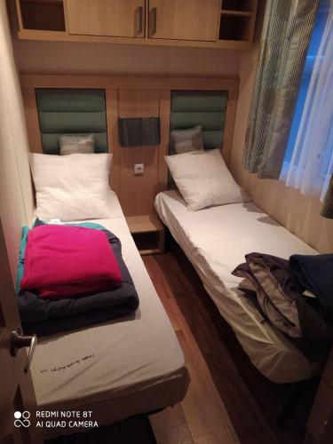- 2 lits dans une petite chambre dans une remorque dans l'établissement Mobil-home anglais 3 chambres, à Pont-Aven