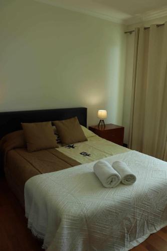 a bedroom with a bed with two towels on it at GuestReady - Rodamar Apartment in Ilhéu do Gorgulho