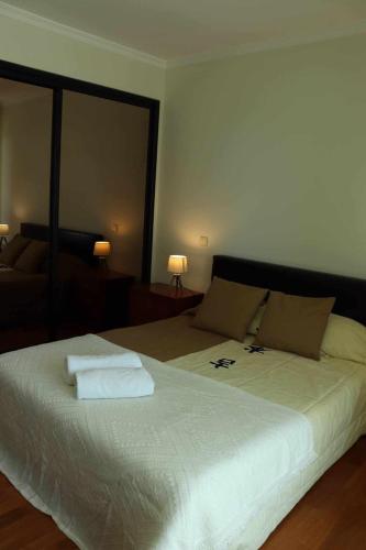 a bedroom with a large bed with two towels on it at GuestReady - Rodamar Apartment in Ilhéu do Gorgulho