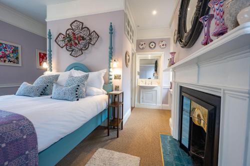 a bedroom with a bed and a fireplace at The Assembly House in central Norwich in Norwich