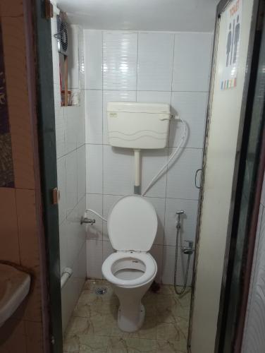 a small bathroom with a toilet and a sink at Awaara Backpackers Hostel, Alibag in Alibag