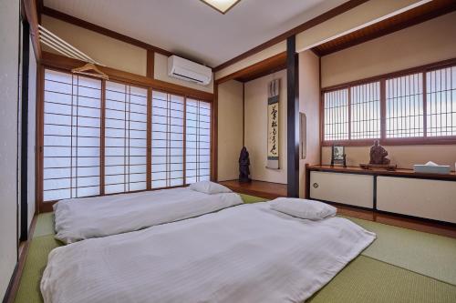 two beds in a room with large windows at APROSTAY旭11 in Fujiyoshida