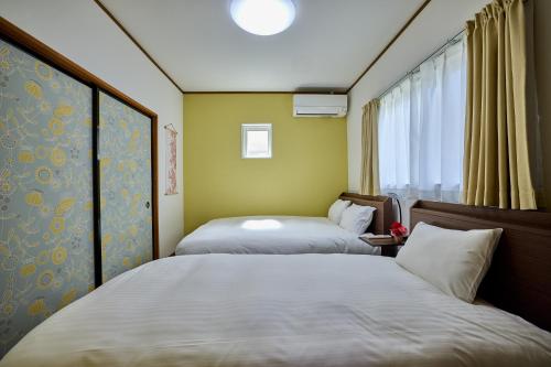 富士吉田市にあるAPROSTAY旭11のベッドが2つと窓のある部屋