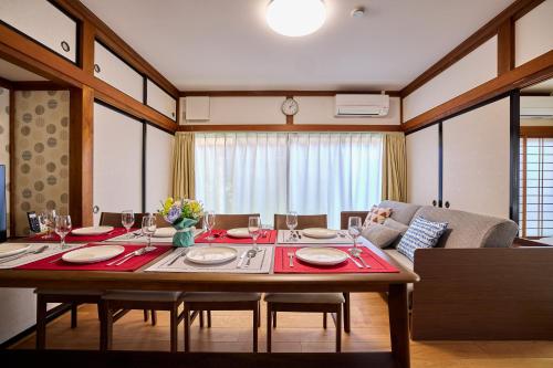 a dining room with a table with chairs and a couch at APROSTAY旭11 in Fujiyoshida