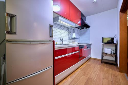 a kitchen with red cabinets and a stainless steel refrigerator at APROSTAY旭11 in Fujiyoshida