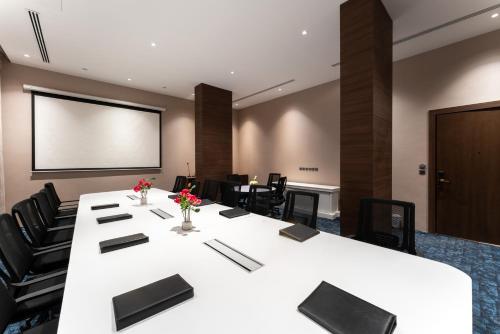 a conference room with a large white table and chairs at Lilac Park Hotel in Tabuk