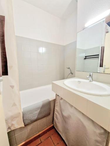 une salle de bain blanche avec un lavabo et une baignoire dans l'établissement Cap Soleil studio 4 pers piscines, tennis, mer, à Saint-Mandrier-sur-Mer