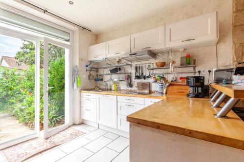 une cuisine avec des placards blancs et une grande fenêtre dans l'établissement Villa Sam Suffy - 10 personnes, à La Seyne-sur-Mer