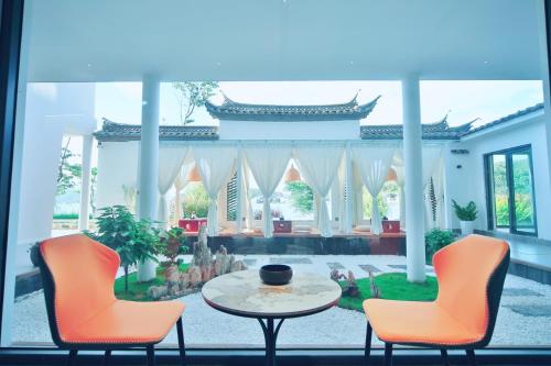 a patio with two chairs and a table in a room at Dali Fish Inn Sea View Hotel in Dali