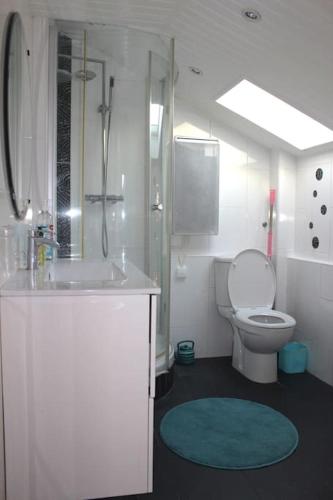 une salle de bain blanche avec un lavabo et des toilettes dans l'établissement Charmant appartement - splendide vue sur Paris, à Montmorency