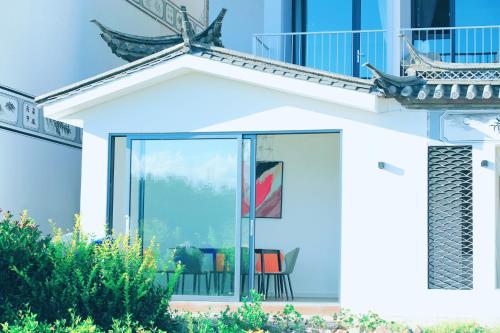 a house with glass doors and a balcony at Dali Fish Inn Sea View Hotel in Dali