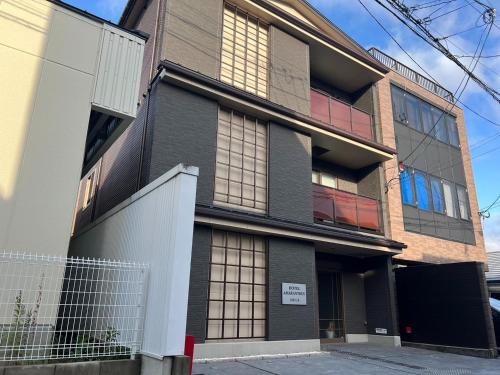 an apartment building with windows on a street at Hotel Amaranth Kyoto Gojo - Vacation STAY 19866v in Kyoto