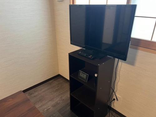 a flat screen tv sitting on top of a black stand at Hotel Amaranth Kyoto Gojo - Vacation STAY 19866v in Kyoto