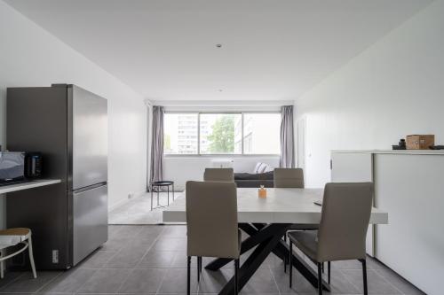 une cuisine et une salle à manger avec une table et des chaises dans l'établissement Appartement 2 Chambres - Porte de Choisy, à Paris