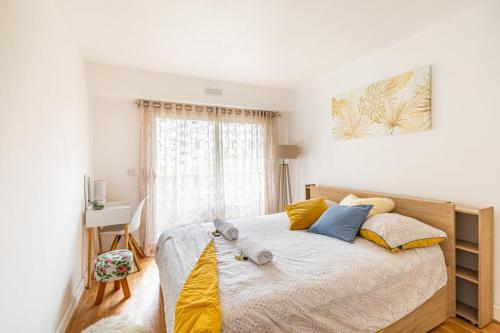 - une chambre avec un lit doté d'oreillers jaunes et bleus dans l'établissement GuestReady - Sunny Side Up with Balcony, à Courbevoie