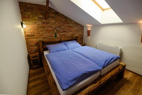 a bedroom with a blue bed in a brick wall at Penzion Folklór na Gruntě in Mikulčice