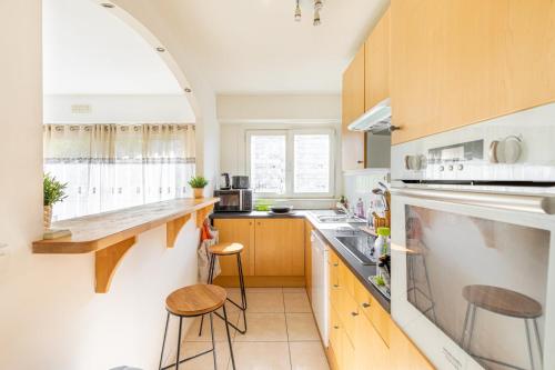 Una cocina con una encimera y dos taburetes en ella. en GuestReady - Sunny Side Up with Balcony, en Courbevoie