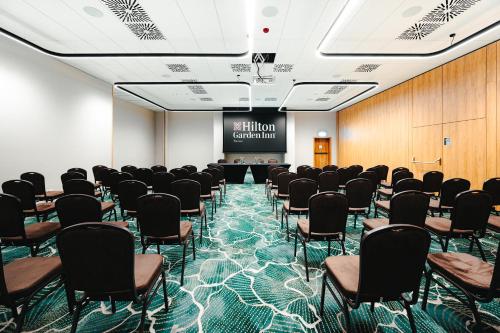 a conference room with chairs and a projection screen at Hilton Garden Inn Radom in Radom
