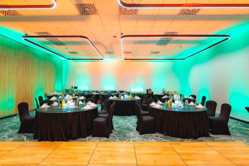 a conference room with tables and chairs and green lighting at Hilton Garden Inn Radom in Radom