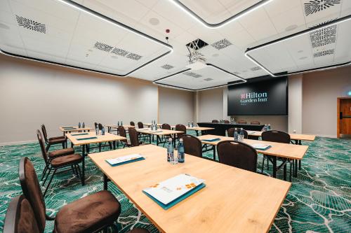 a conference room with tables and chairs and a screen at Hilton Garden Inn Radom in Radom