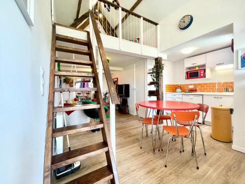 une cuisine et une salle à manger avec une table et des chaises dans l'établissement La Petite Eole - Déco 70's, Entre Rouen et Dieppe, à Fresnay-le-Long