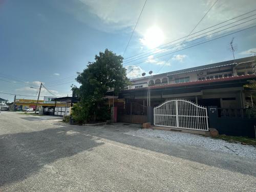 a building with a gate on the side of a street at Jenny Homestay in Teluk Intan