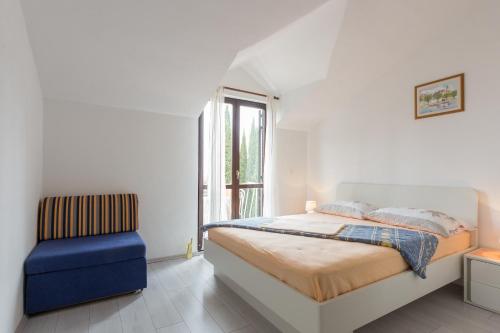 Un dormitorio blanco con una cama y una silla azul. en Villa Anka 2, en Cavtat