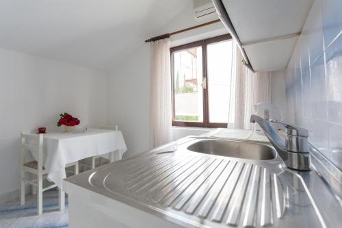 cocina con fregadero, mesa y ventana en Villa Anka 2, en Cavtat