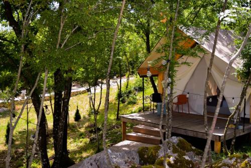 una tenda nel bosco con portico in legno di Oblun Eco Resort - New Glamping Tents near Lake Skadar a Podgorica