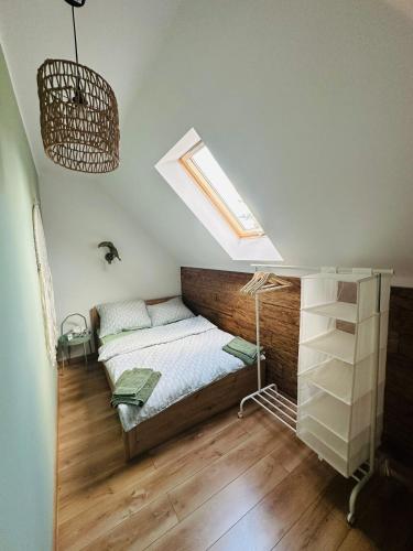 a bedroom with a bed and a skylight at Cicho Sza domki letniskowe Cichowo in Cichowo