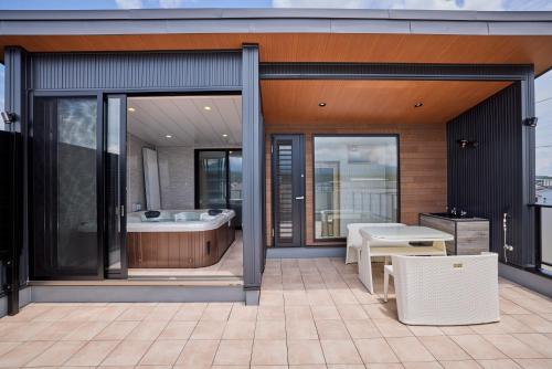 a bathroom with a tub and a table on a balcony at Miire Mt Fuji Natural in Fujikawaguchiko