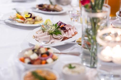 a white table with plates of food on it at Hotel Mazovia Airport Modlin in Nowy Dwór Mazowiecki