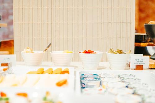 a table with white bowls of food on it at Hilton Garden Inn Radom in Radom